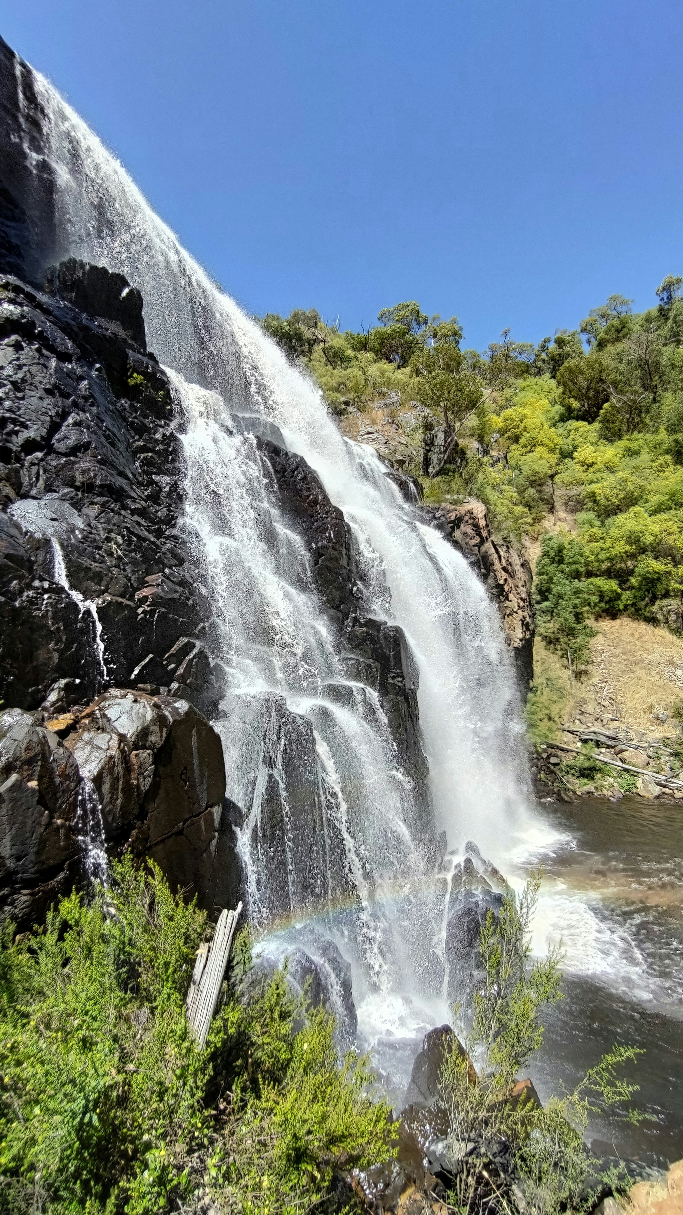Ein Wasserfall mit einem Regenbogen in der Mitte