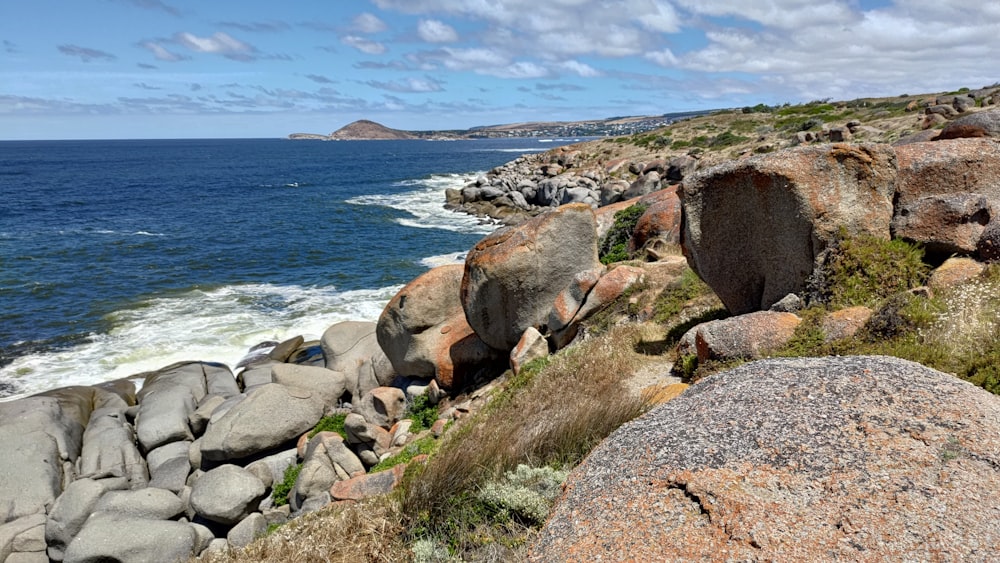 a rocky shore with a body of water in the distance