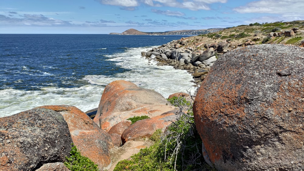 a rocky shore line with a body of water in the distance