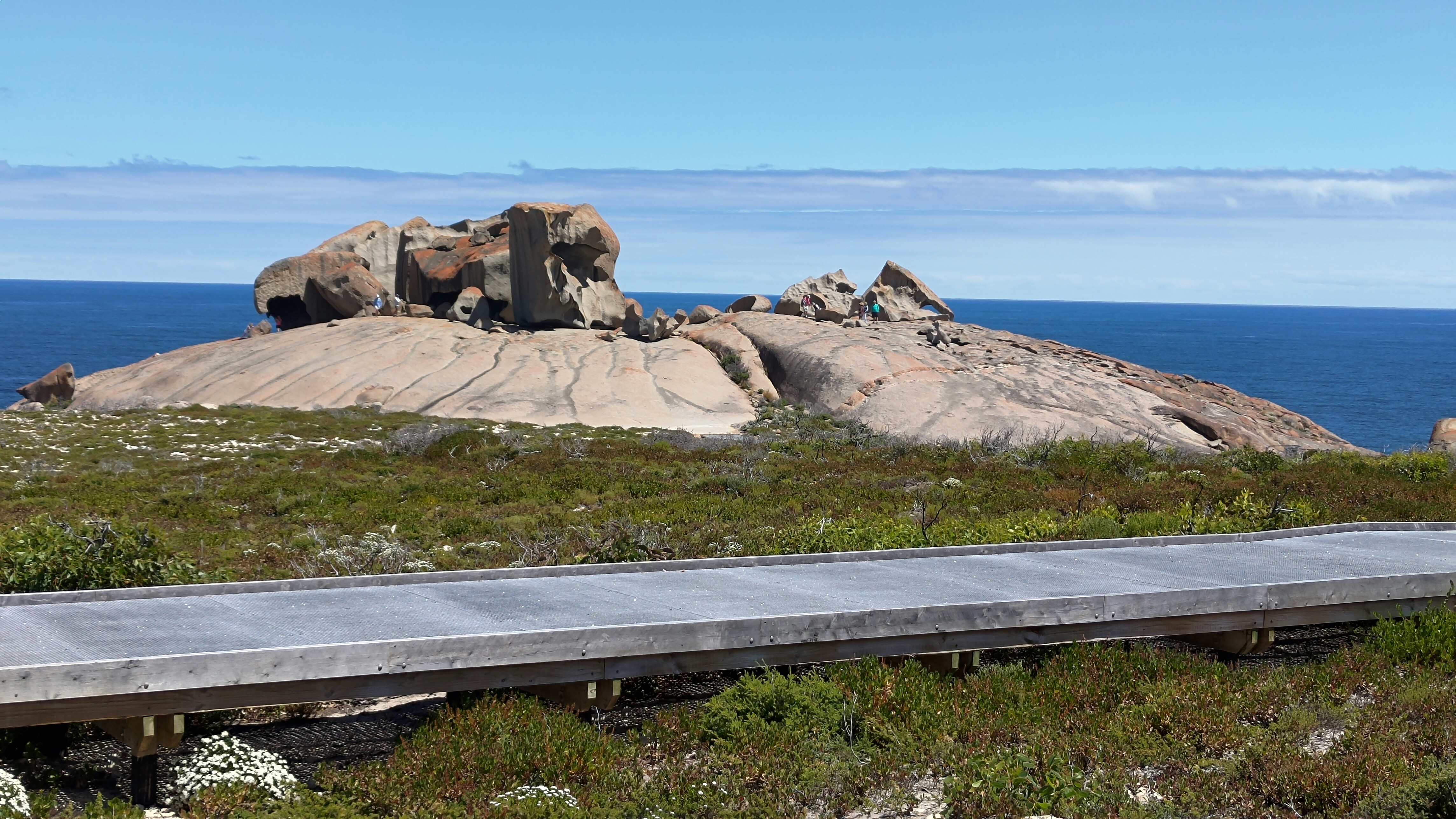 a bench sitting on top of a grass covered hillside