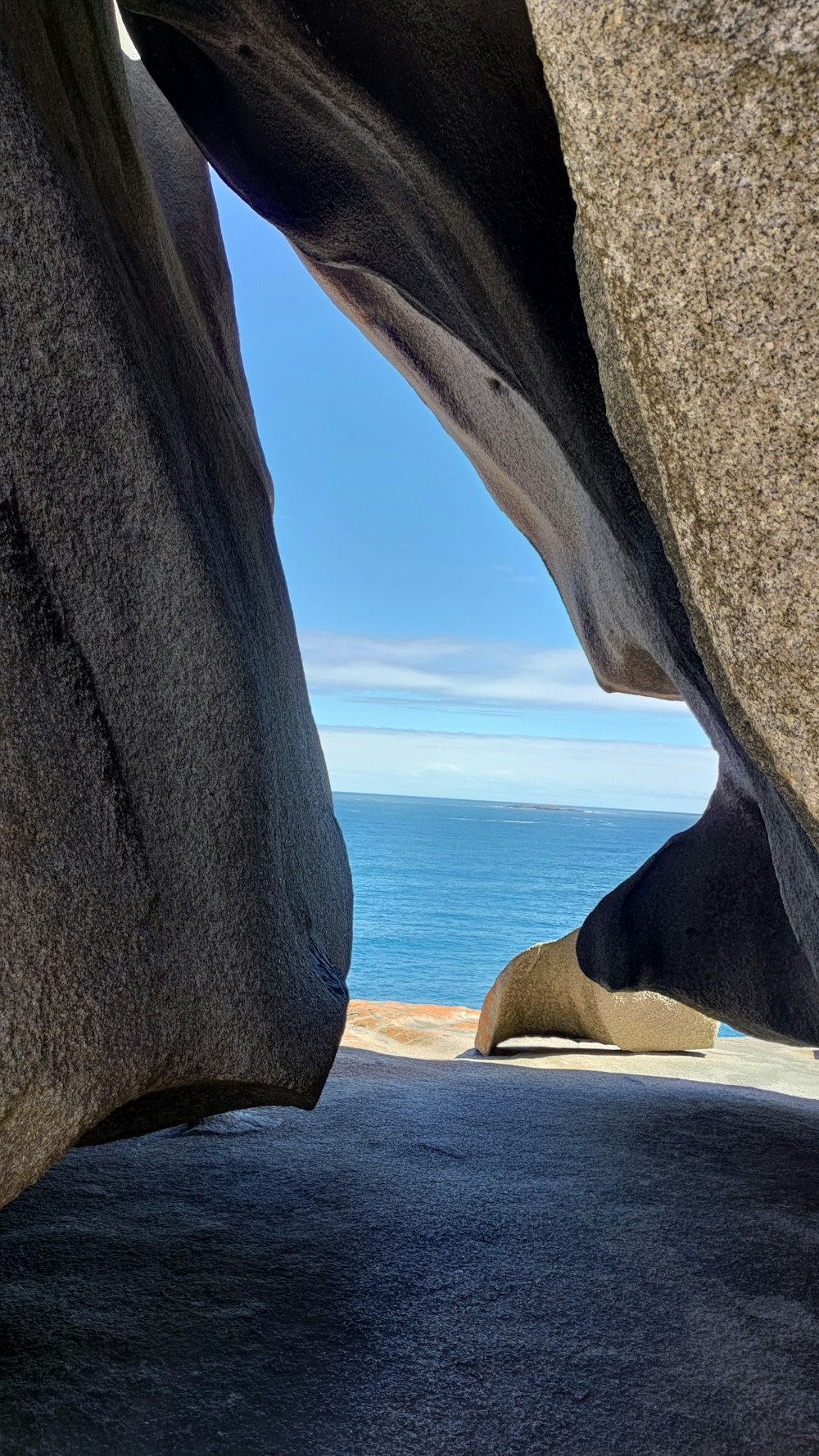 a view of the ocean through a crack in a rock