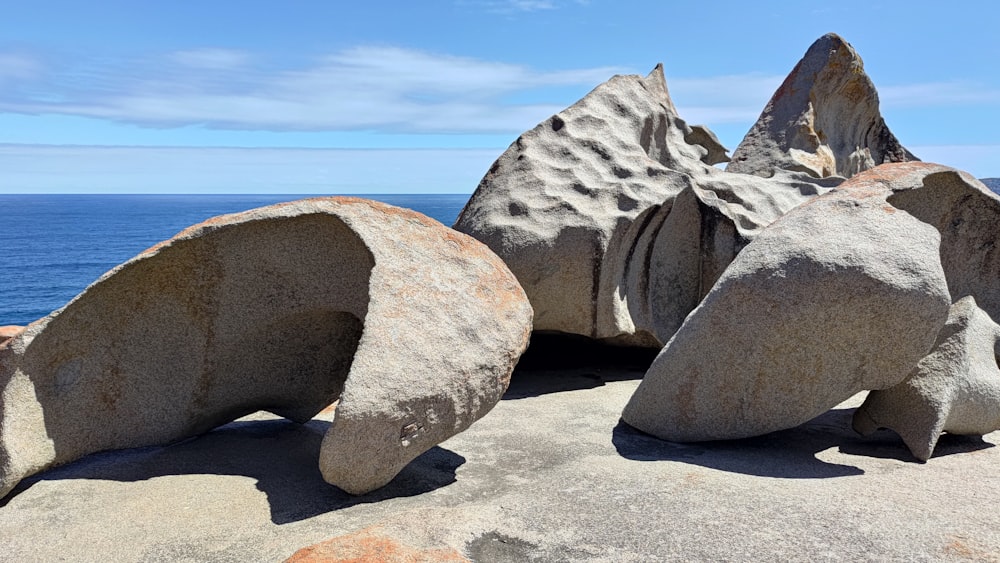 a large rock formation sitting on top of a beach next to the ocean