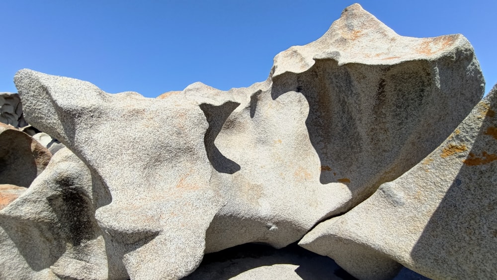 a large rock formation with a blue sky in the background