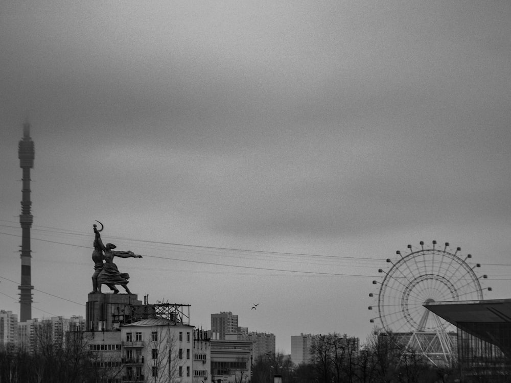 a black and white photo of a statue on top of a building