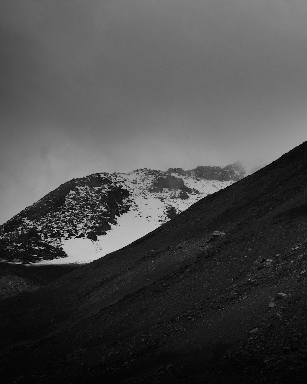 a black and white photo of a snow covered mountain