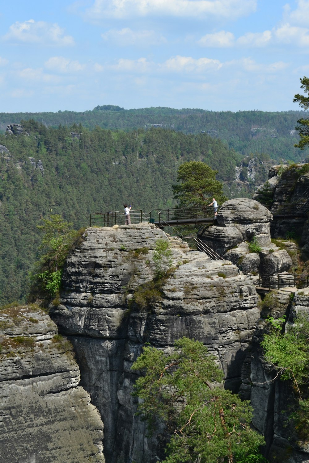 a couple of people standing on top of a cliff