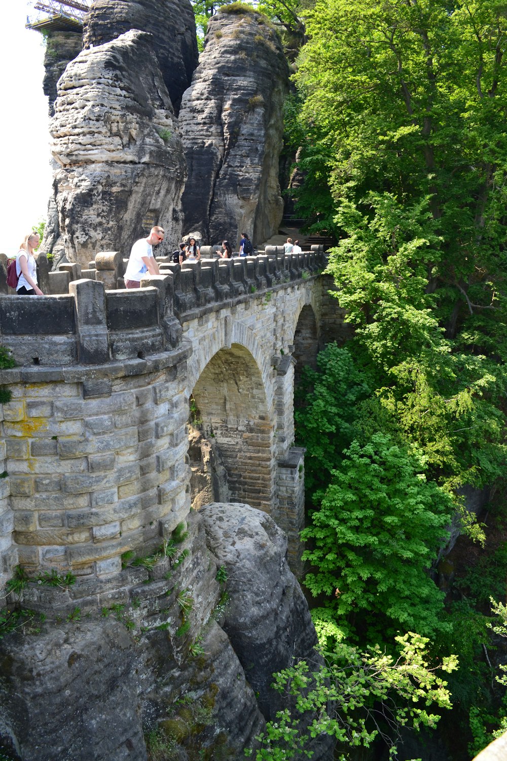 a group of people standing on top of a stone bridge