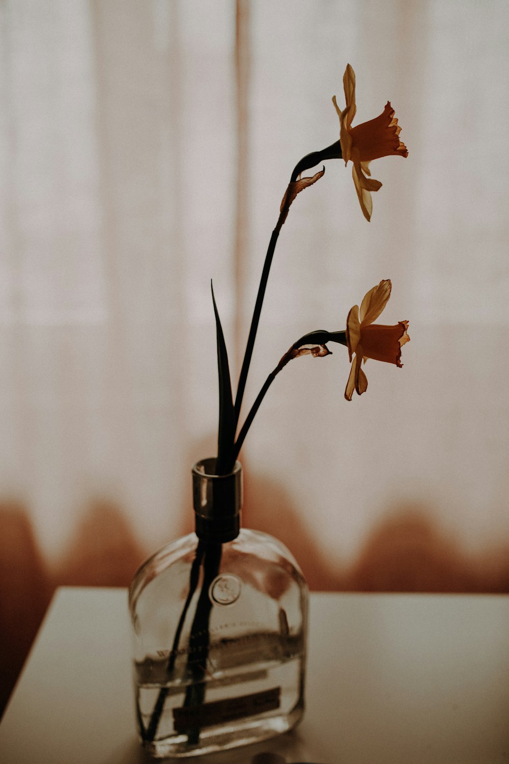 a glass vase with flowers in it on a table