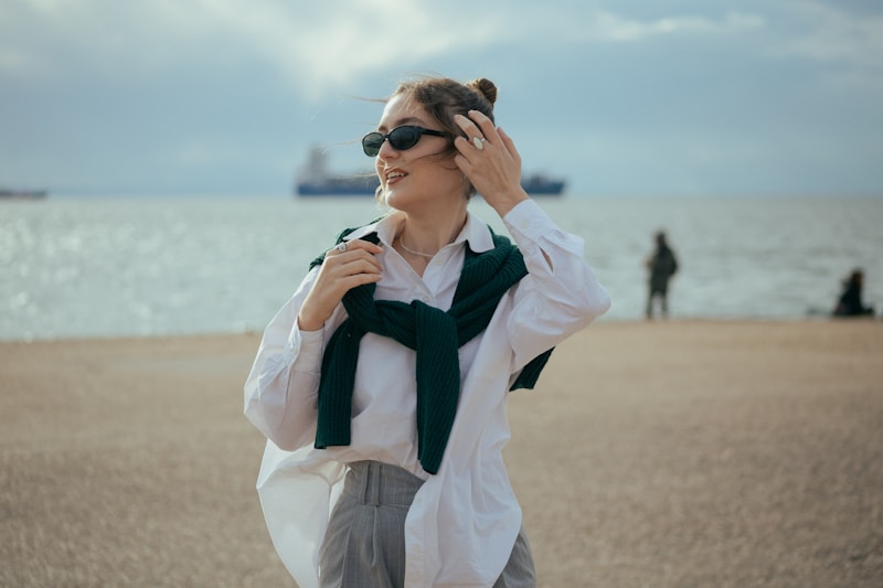 Femme chic en lunettes sur plage
