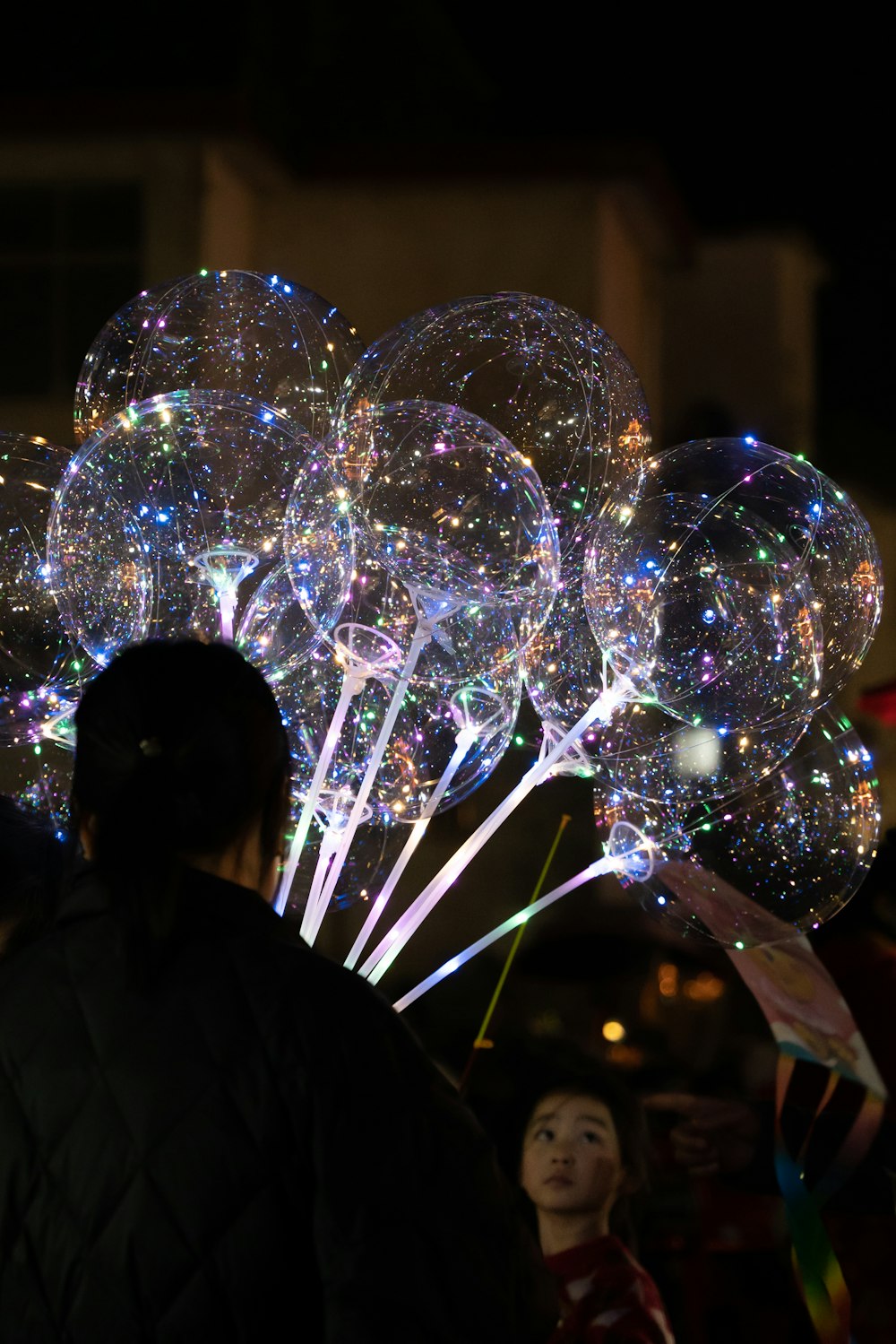 a person standing in front of a bunch of balloons