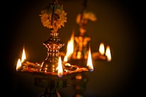 Close-up of traditional brass lamps lit during the Ganga Aarti, casting warm golden light.
