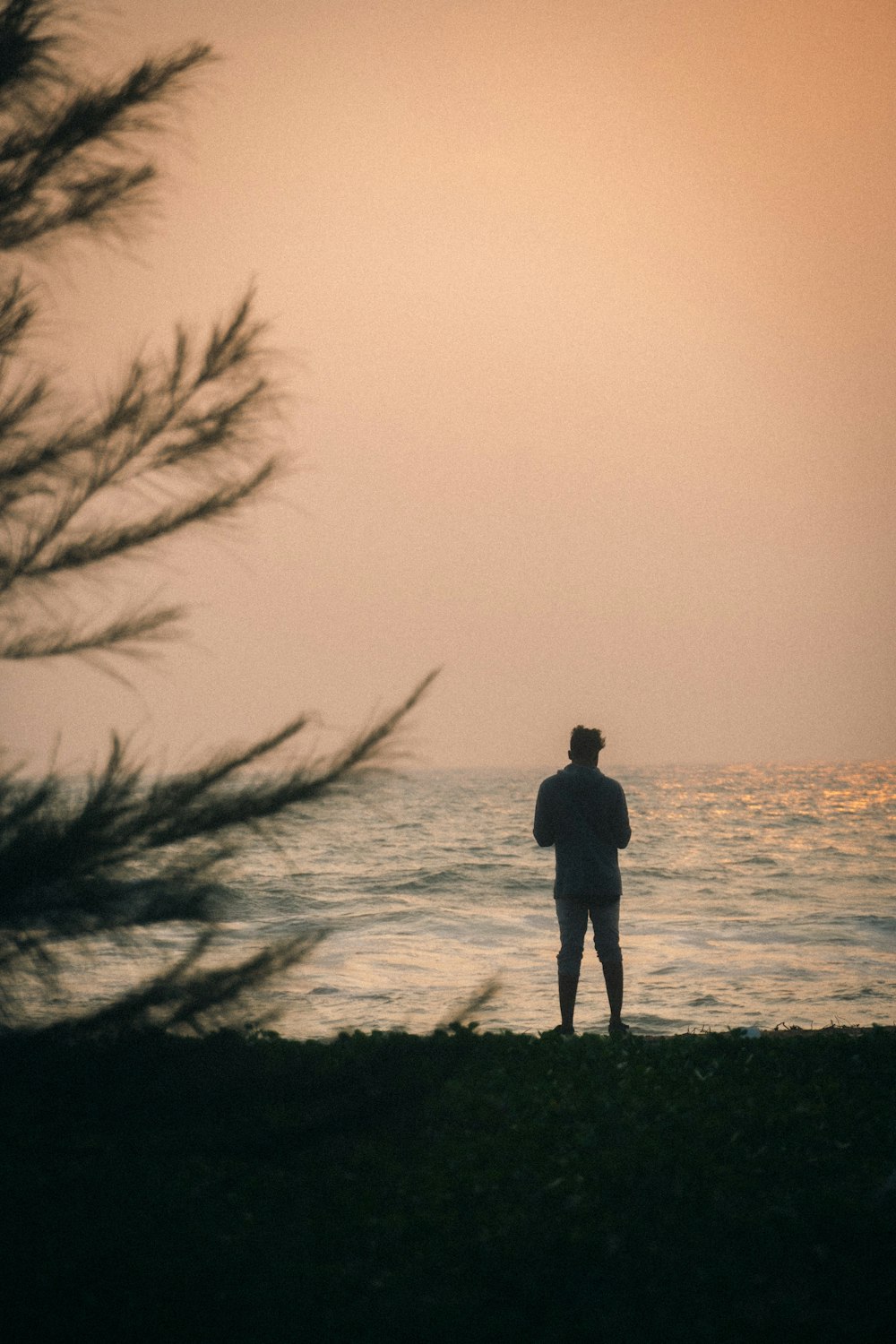 a man standing on a beach next to the ocean