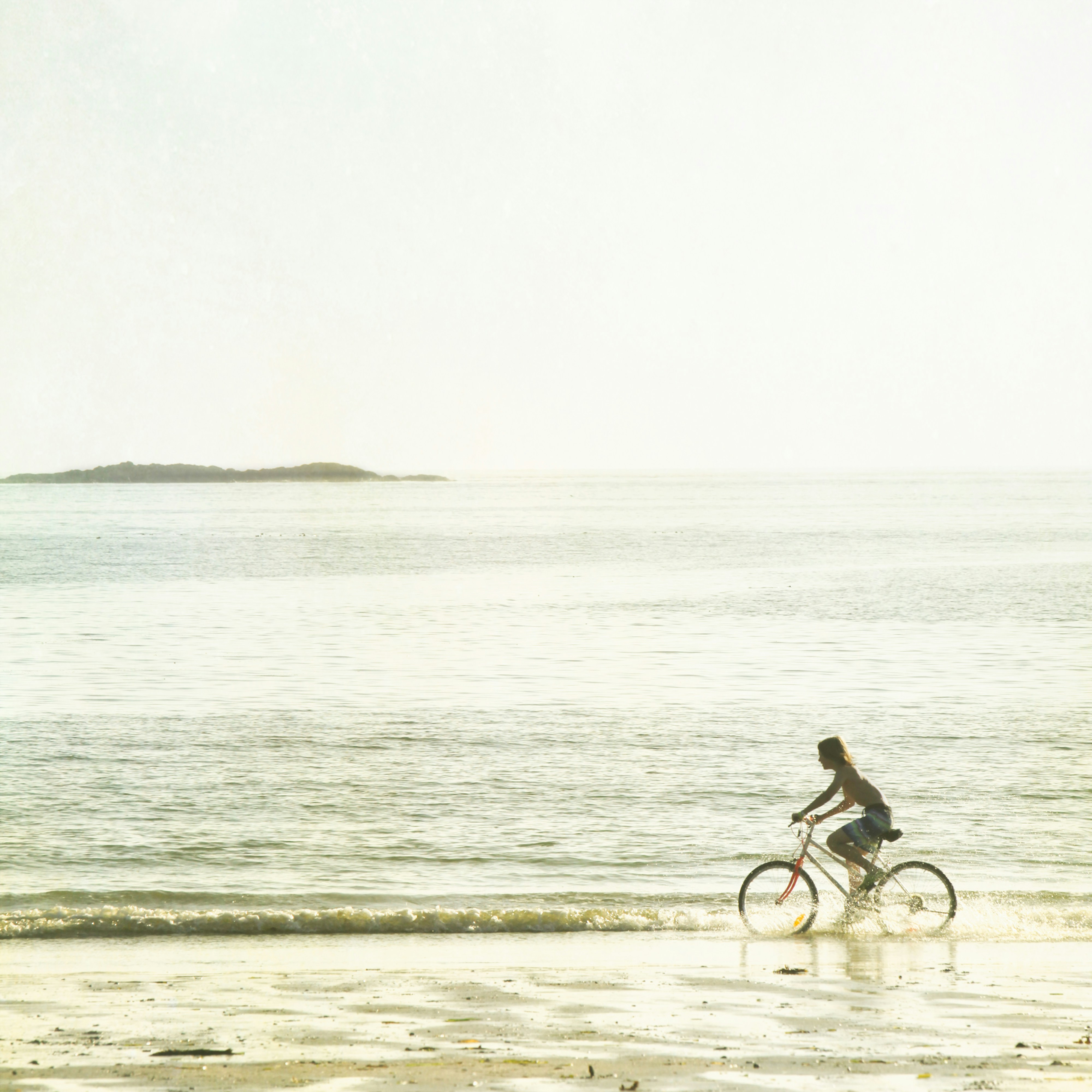 a person riding a bike on a beach
