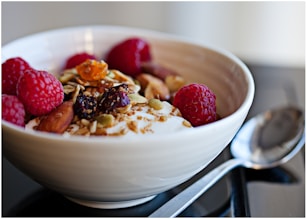 a bowl of granola with raspberries and nuts