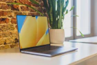 A high-resolution laptop open on a desk with a modern workspace