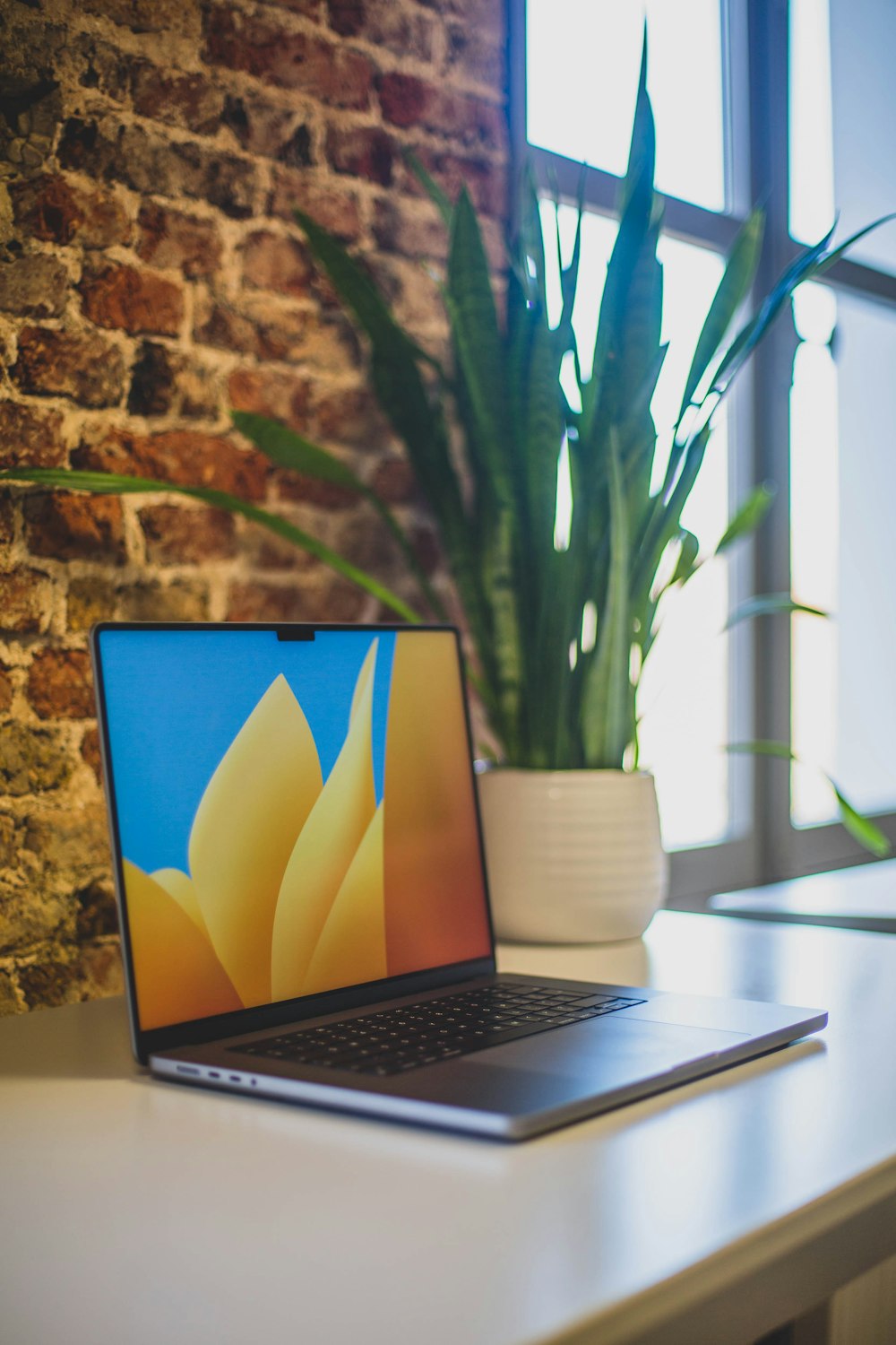 um computador portátil sentado em cima de uma mesa branca