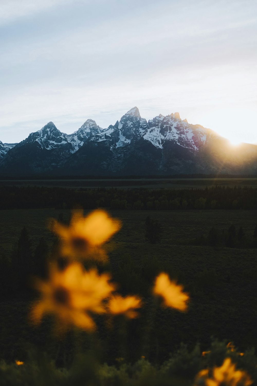 the sun is setting over the mountains in the distance