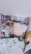 A creatively decorated scrapbook page featuring photos, handwritten notes, and artistic embellishments. The page includes a prominent love letter, images of a couple, and the word 'Erkenci Kus'. The surrounding elements include a feather pen, a small glass jar, coins, and an ornate pocket watch lying on a lace tablecloth.