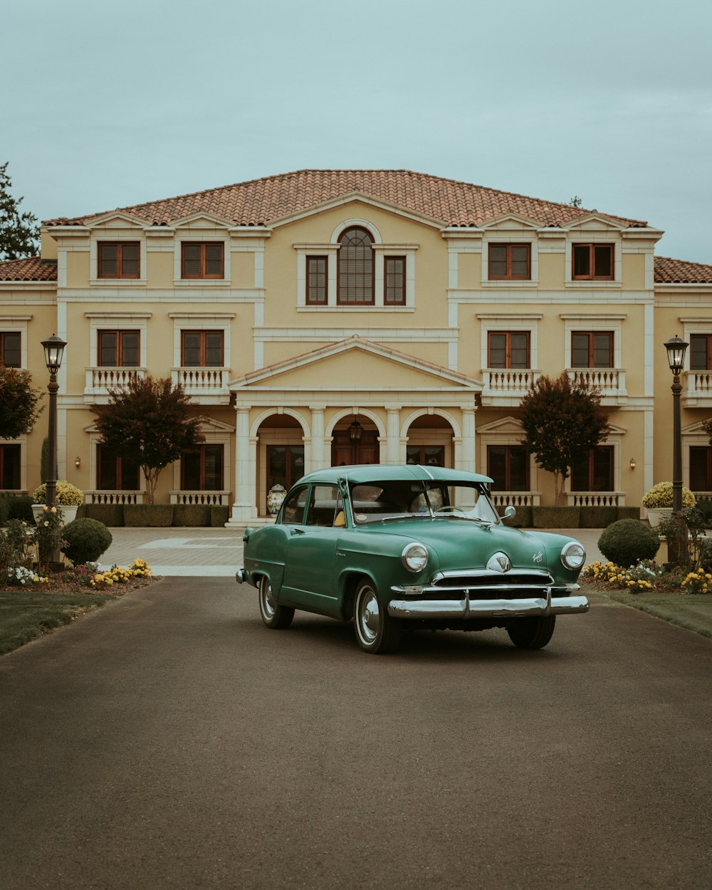 a green car parked in front of a large building