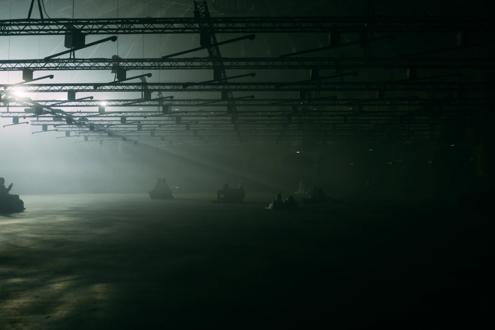Dark interior of an empty commercial space, a single beam of light piercing through the ceiling