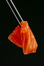 a piece of sushi with chopsticks sticking out of it