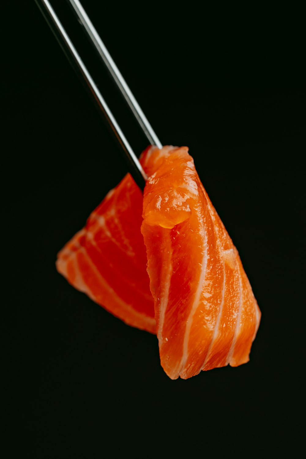 a piece of sushi with chopsticks sticking out of it