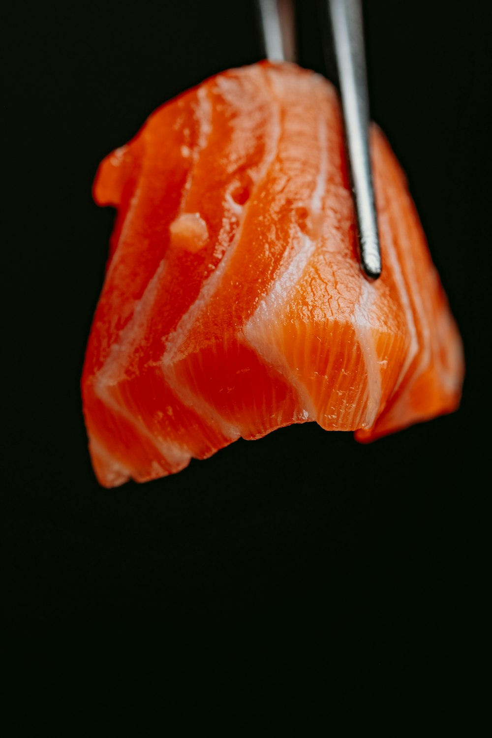 a piece of sushi with chopsticks sticking out of it