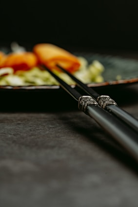 A close-up of elegant wooden chopsticks resting on a bamboo mat, highlighting their smooth finish and craftsmanship.