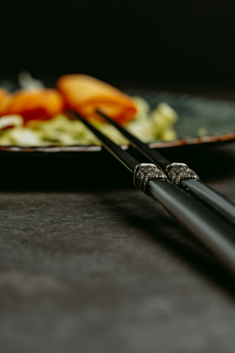 two chopsticks resting on a plate of food