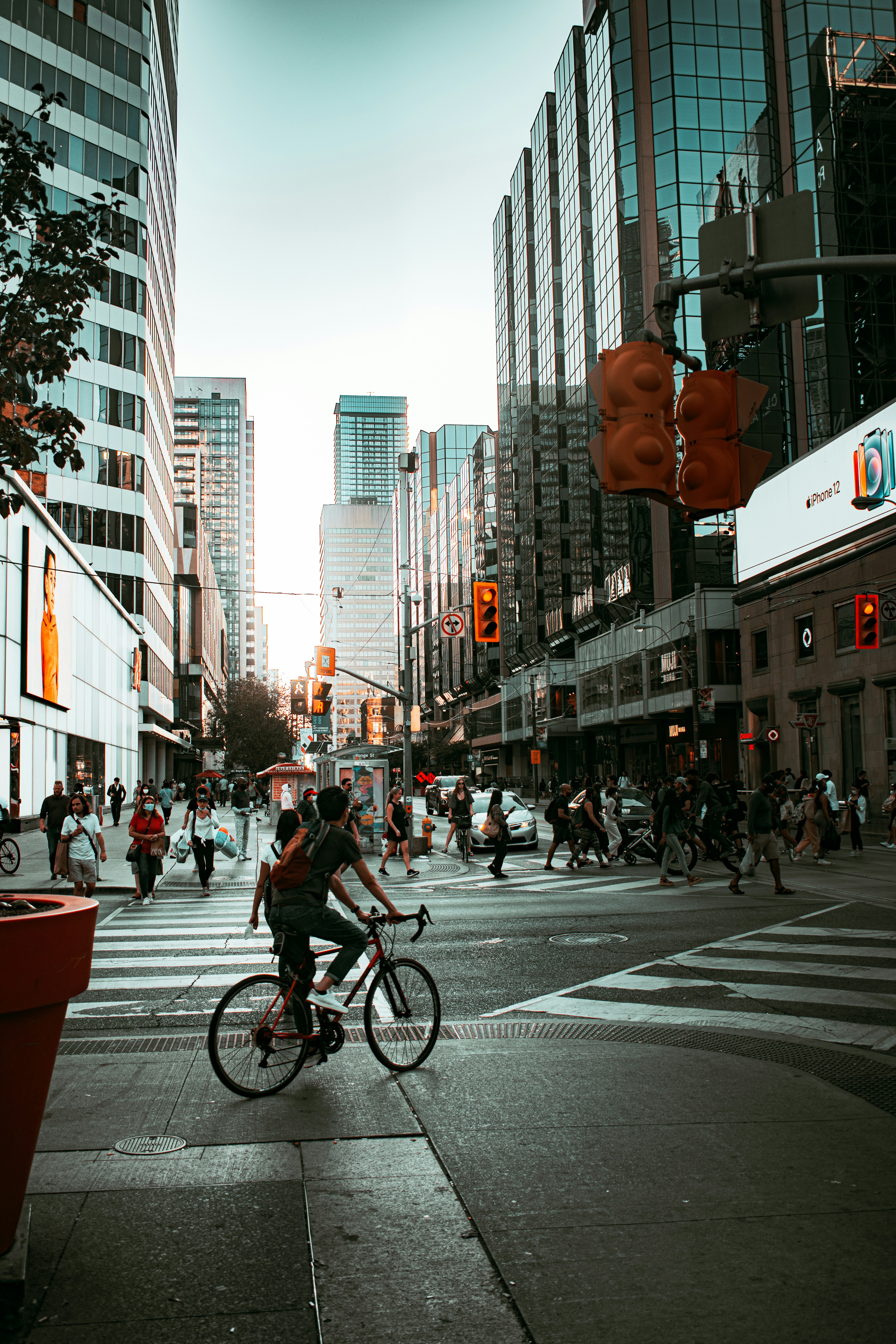 a man riding a bike down a street next to tall buildings
