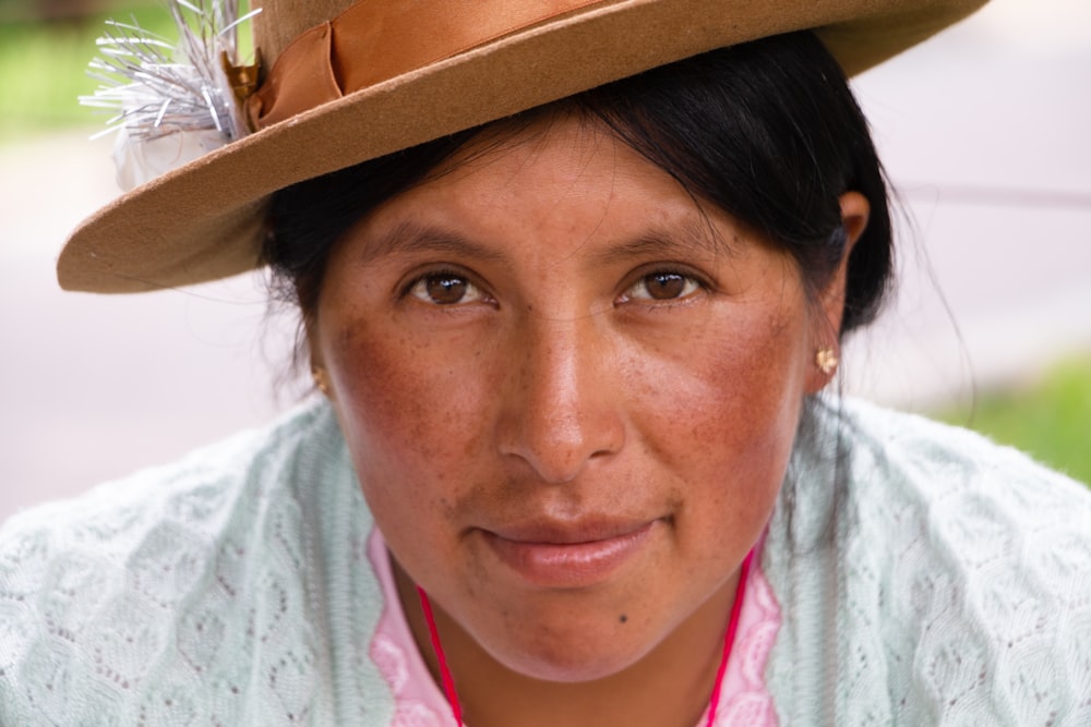 a woman wearing a brown hat and a pink shirt