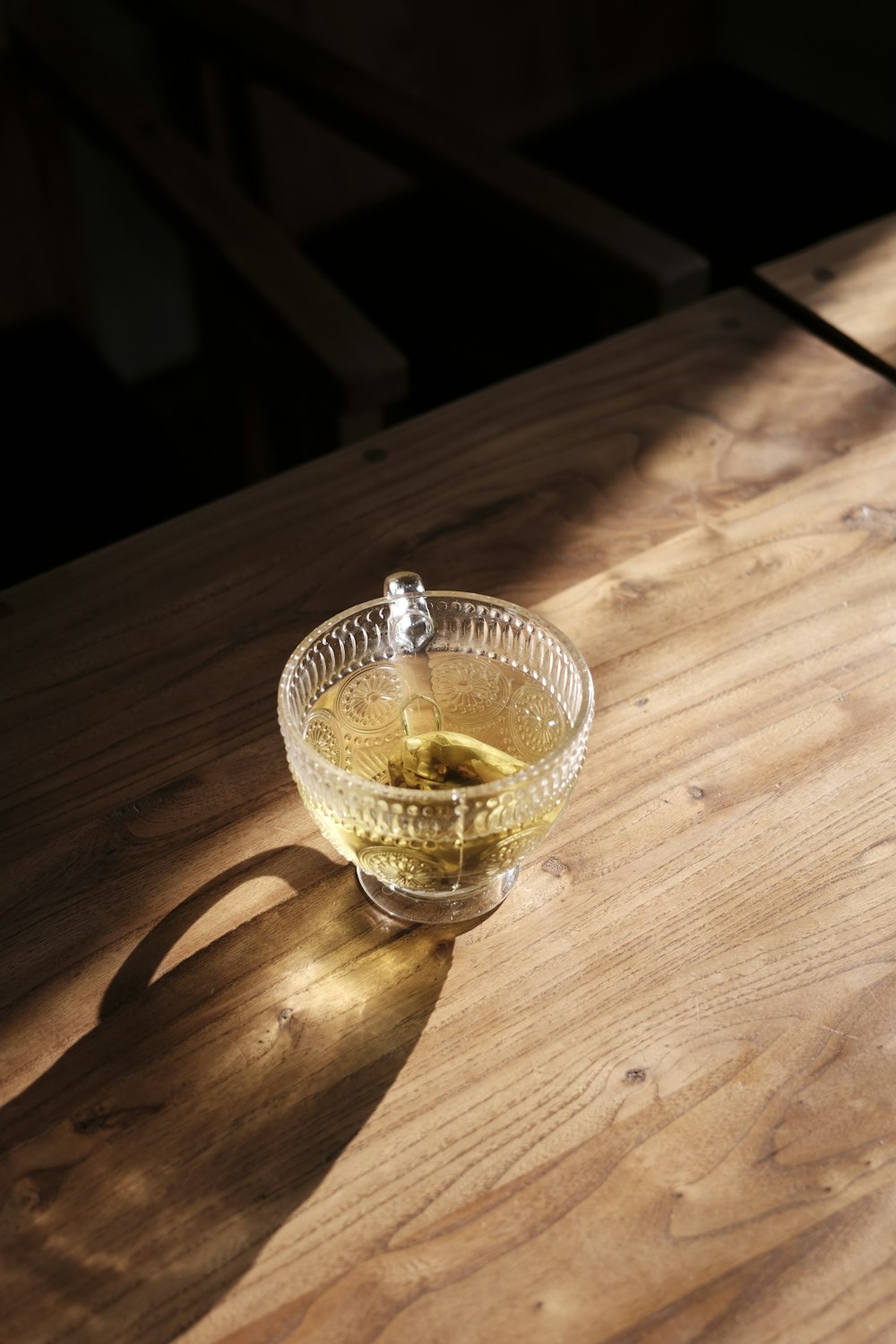 a glass bowl of olives on a wooden table