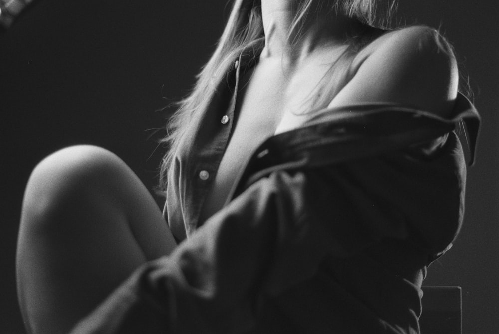 a black and white photo of a woman holding a guitar