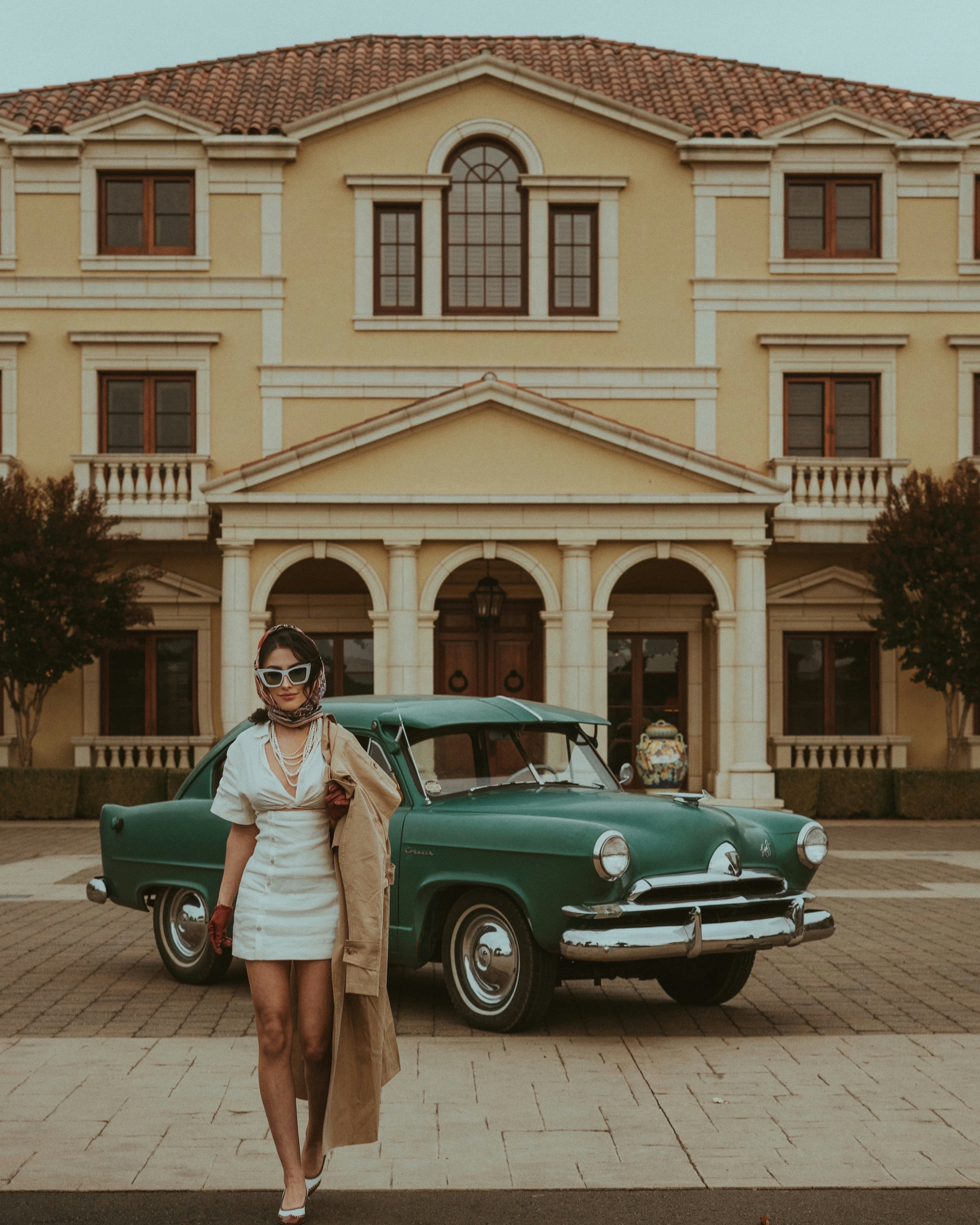 a woman standing in front of a green car