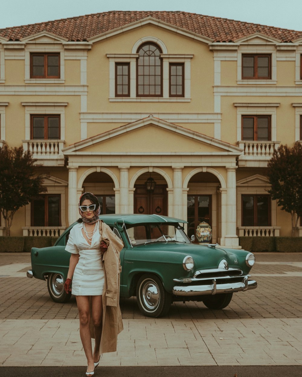 a woman standing in front of a green car