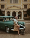 a woman sitting on the hood of a green car