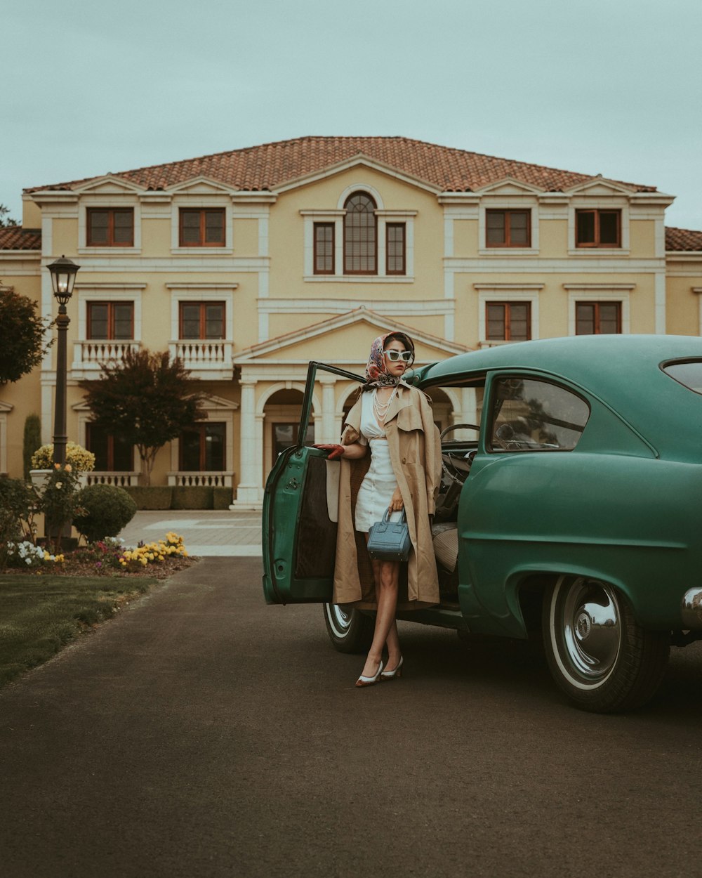 a woman standing next to a green car