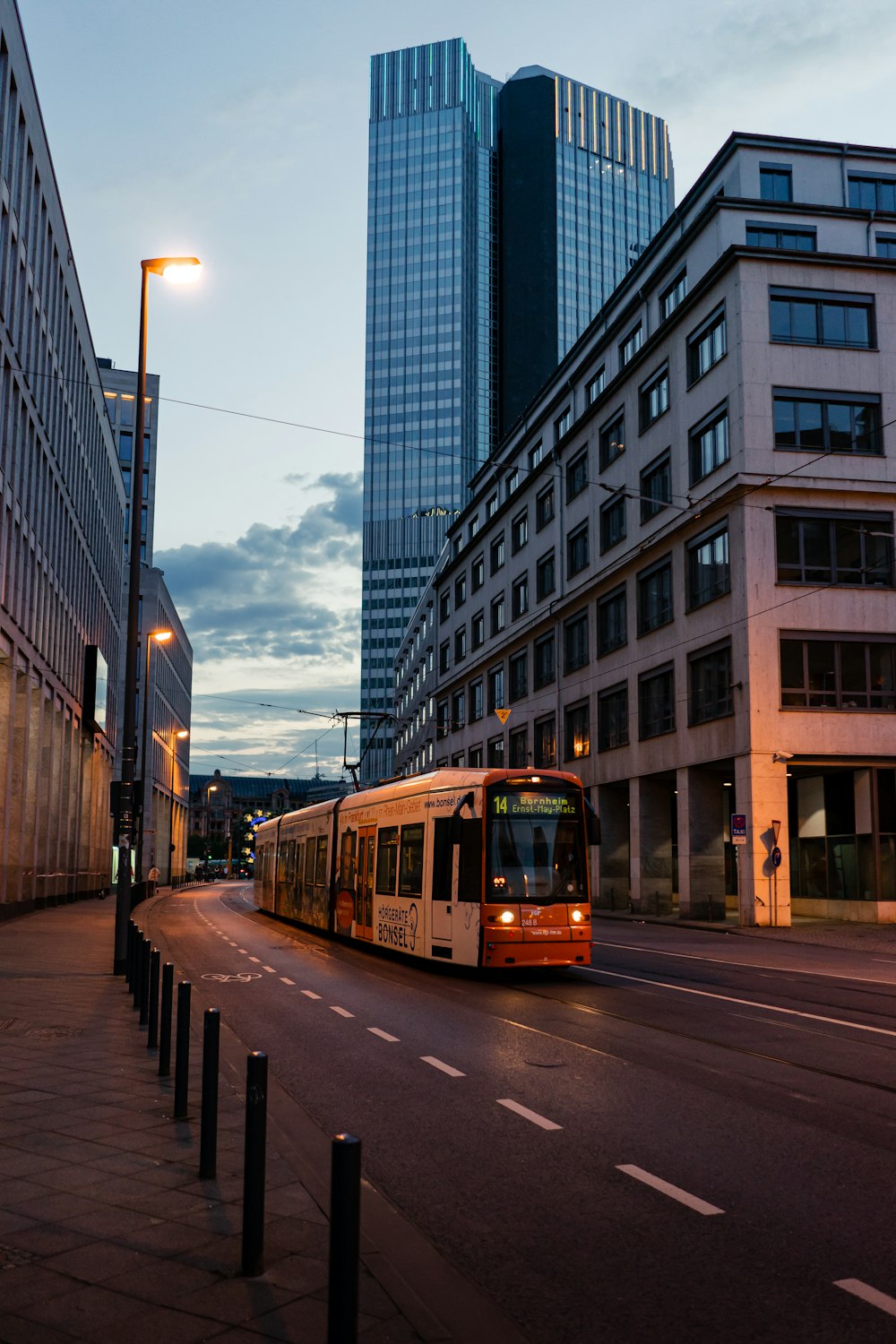 a bus driving down a street next to tall buildings