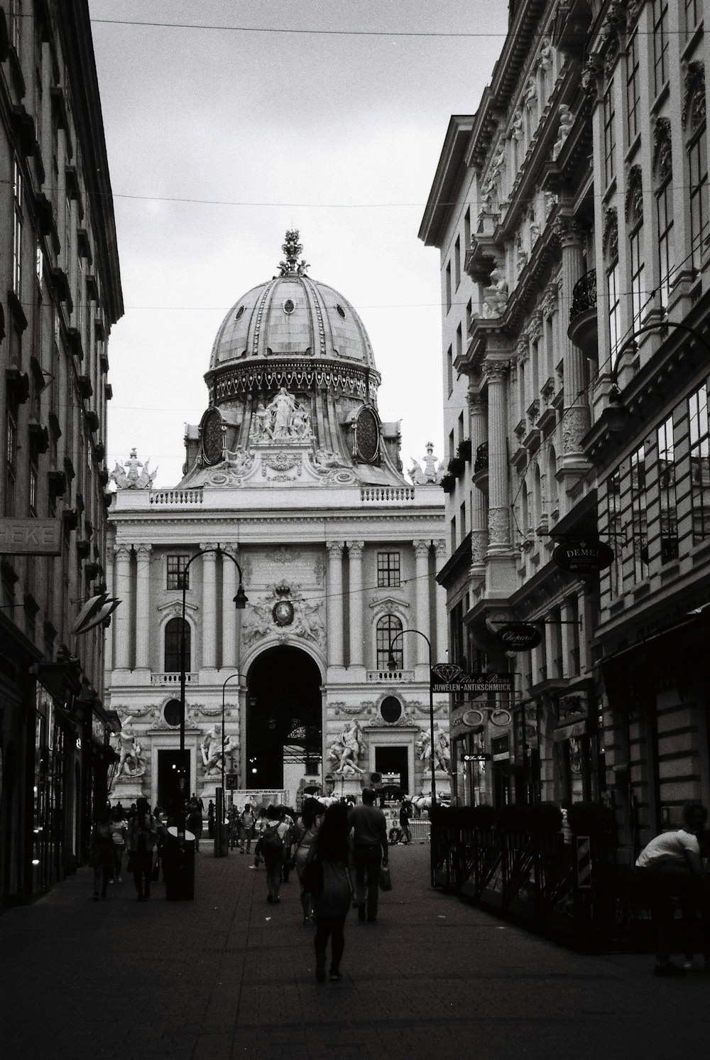 a black and white photo of people walking down a street