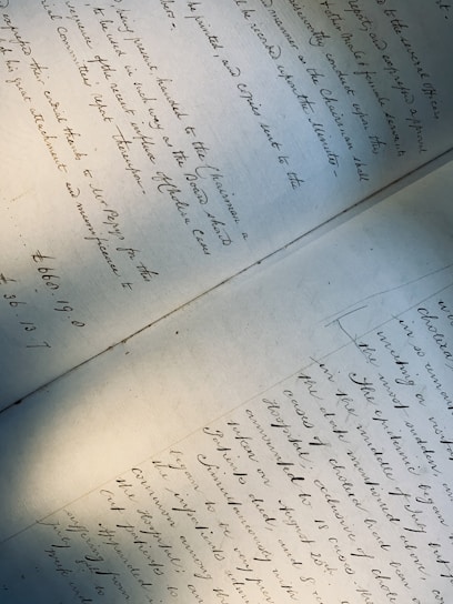 A handwritten document featuring elegant cursive writing, covering two pages laid out on a flat surface. The text is slightly tilted, with shadows cast across the paper, giving a sense of age and historical importance.