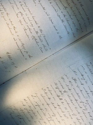 A handwritten document featuring elegant cursive writing, covering two pages laid out on a flat surface. The text is slightly tilted, with shadows cast across the paper, giving a sense of age and historical importance.