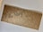 A brown, textured cardboard cover with elegant, cursive black lettering that reads 'The Story' enclosed in quotation marks. The object appears to be placed on a light gray surface.