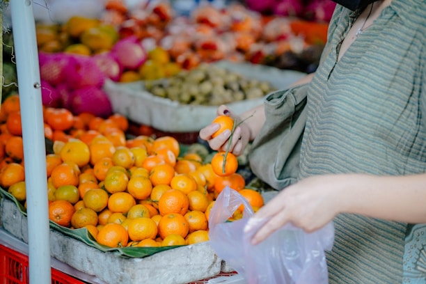 Happy customer selecting fruits at an outdoor organic produce stand.