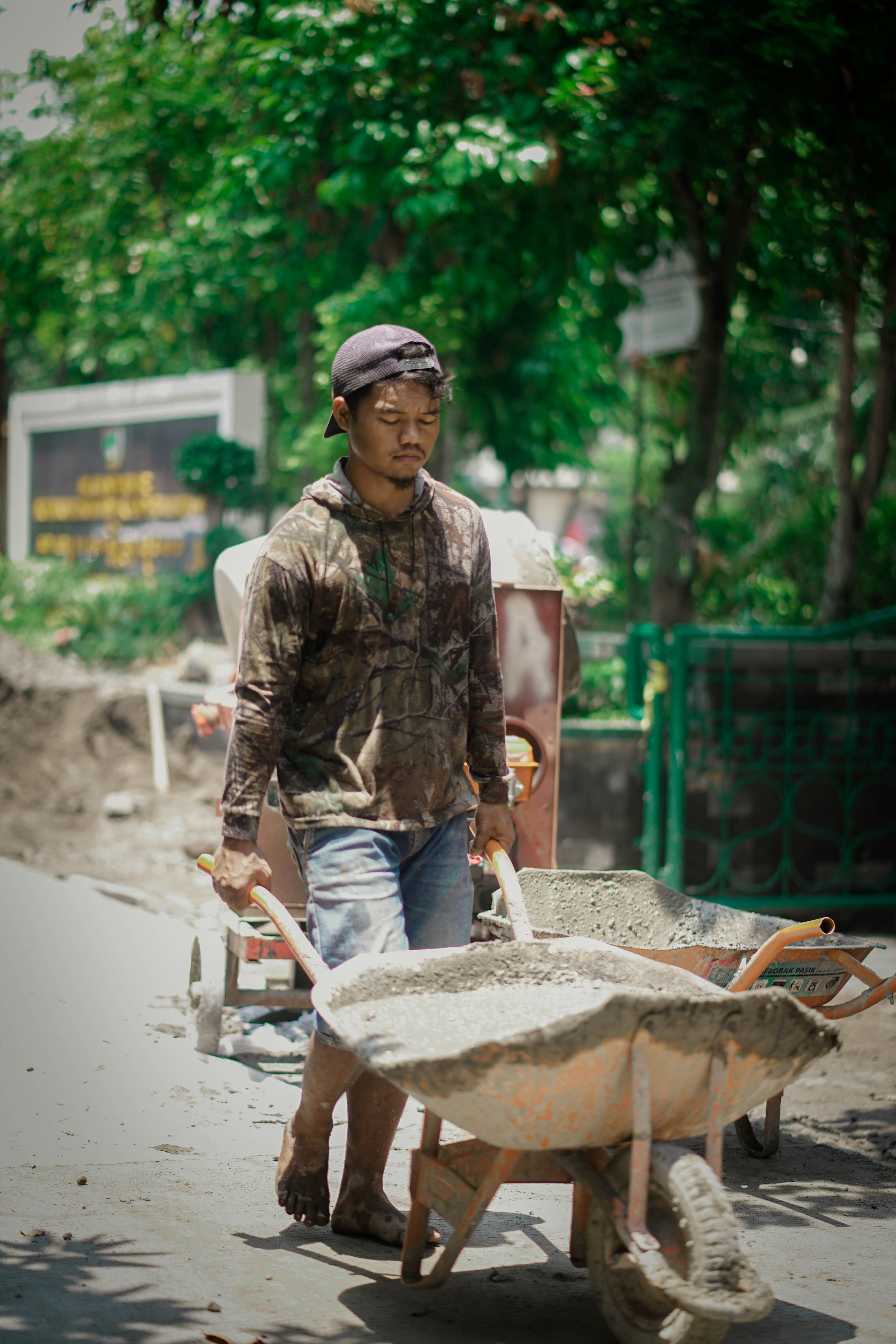 a man pushing a wheelbarrow down a street