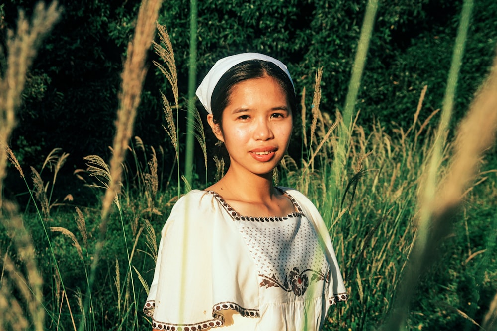a young girl standing in a field of tall grass
