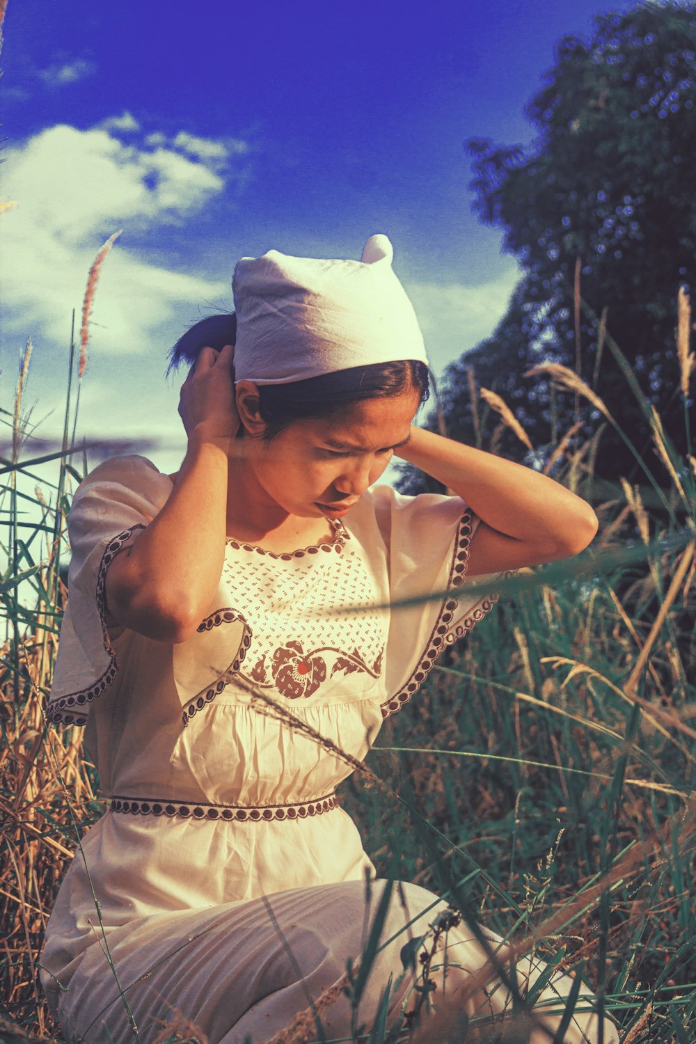 a woman sitting in a field of tall grass