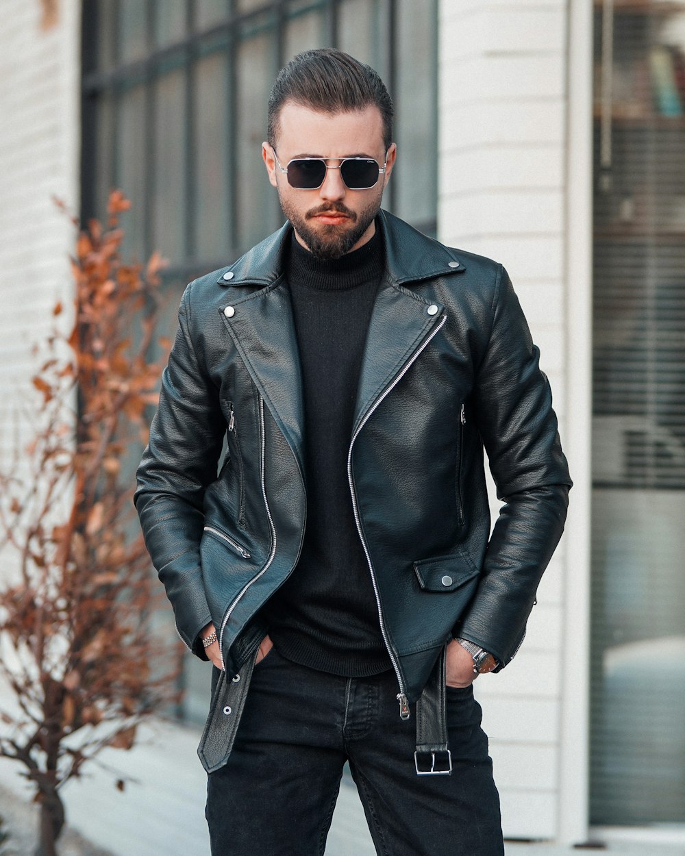 un homme avec une barbe portant une veste en cuir noir