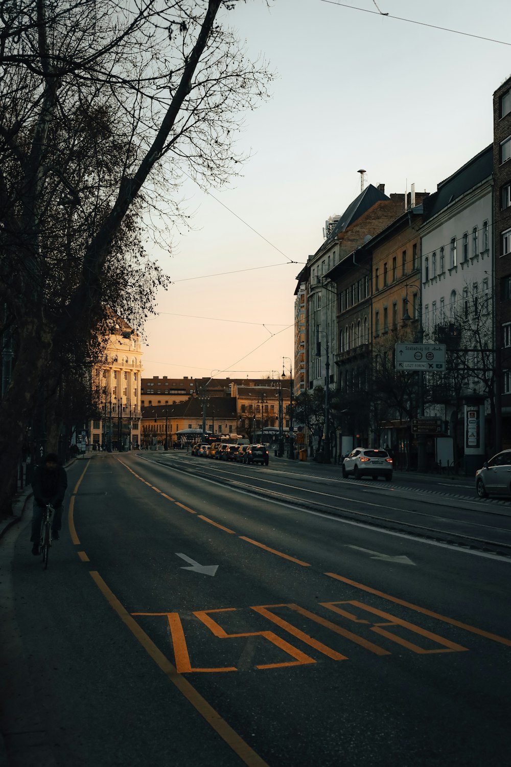 a person riding a bike down a street next to tall buildings