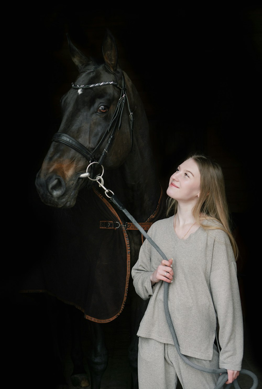 a woman is standing next to a horse