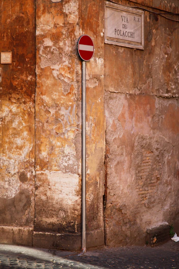 a red and white street sign sitting on the side of a building